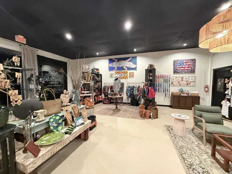 Wide view inside Ghost Orchid Studio showing artwork, handmade gifts, display tables, and seating