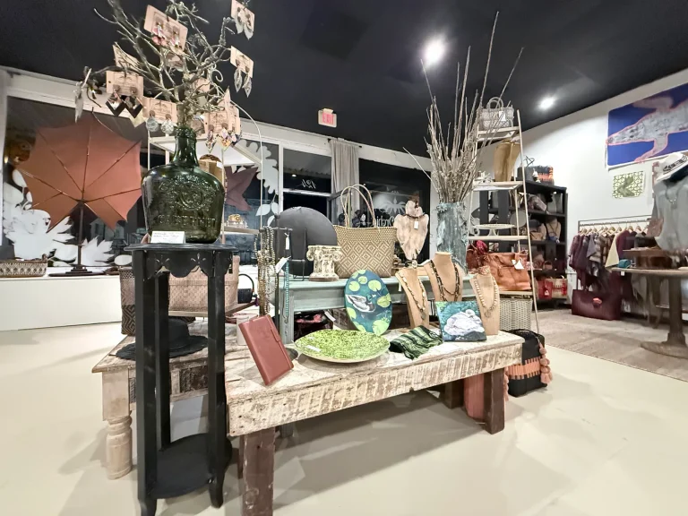 Handmade decorative pieces and gifts arranged on a wooden display table inside Ghost Orchid Studio