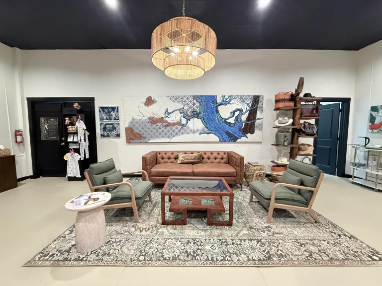 Ghost Orchid Studio seating area with a sofa, armchairs, rug, and artwork on the walls