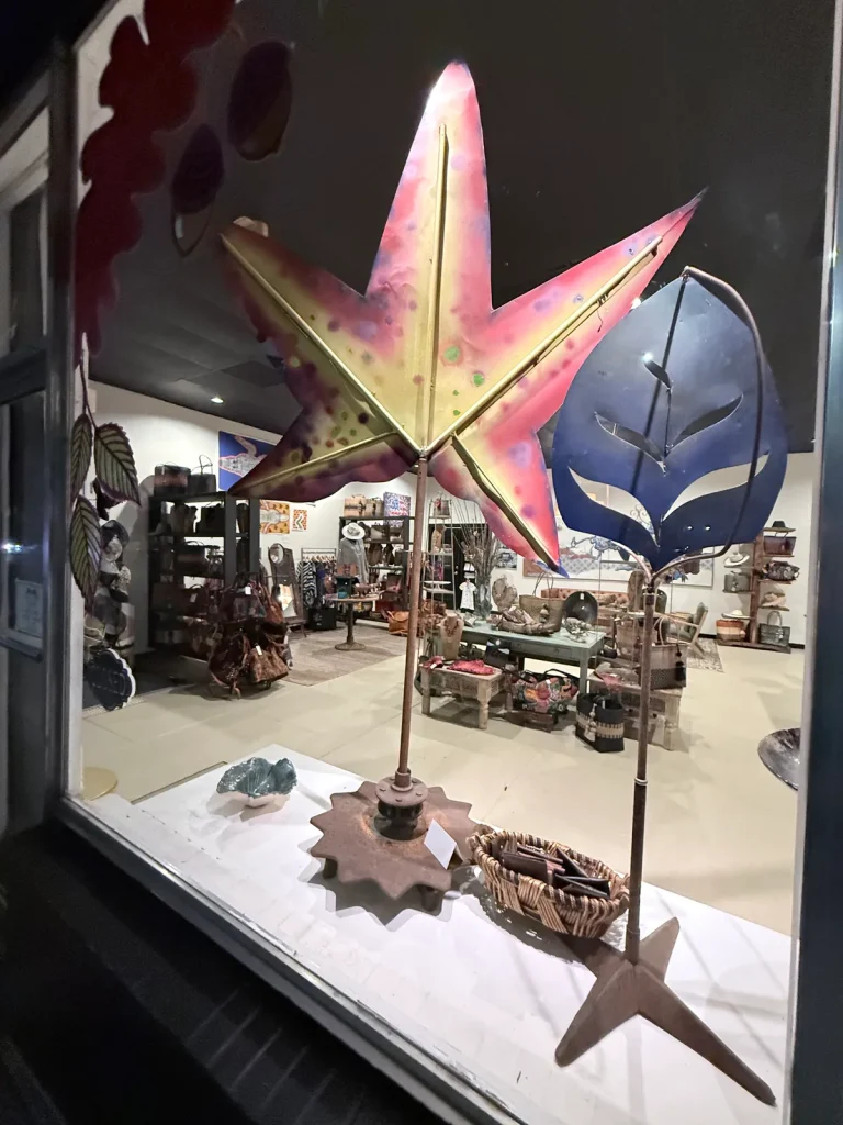 Colorful star and leaf sculptures displayed in the Ghost Orchid Studio window